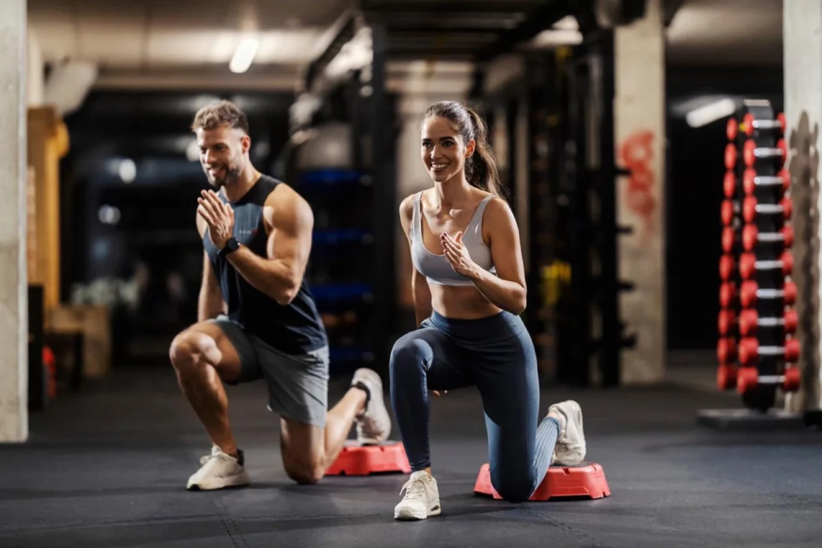 Two clients training with a Trainer Pro coach in a building gym