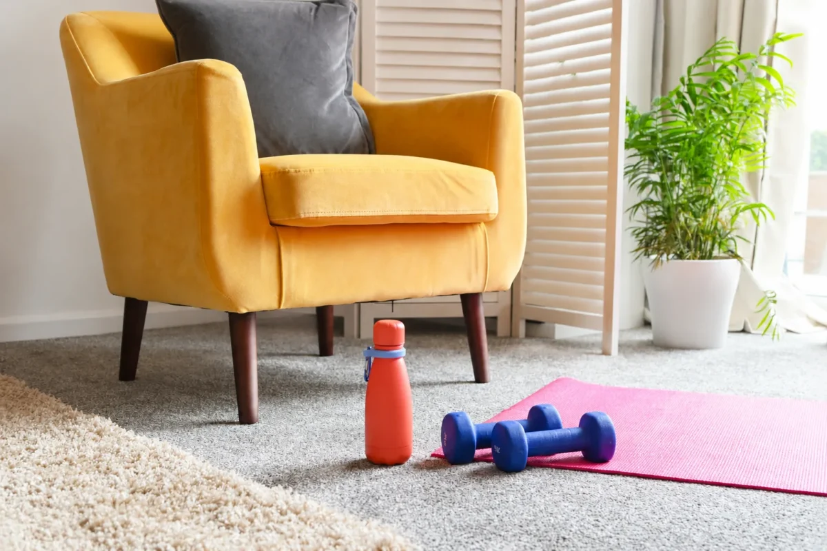 Senior personal trainer guiding a client through a supported lower-body movement at home